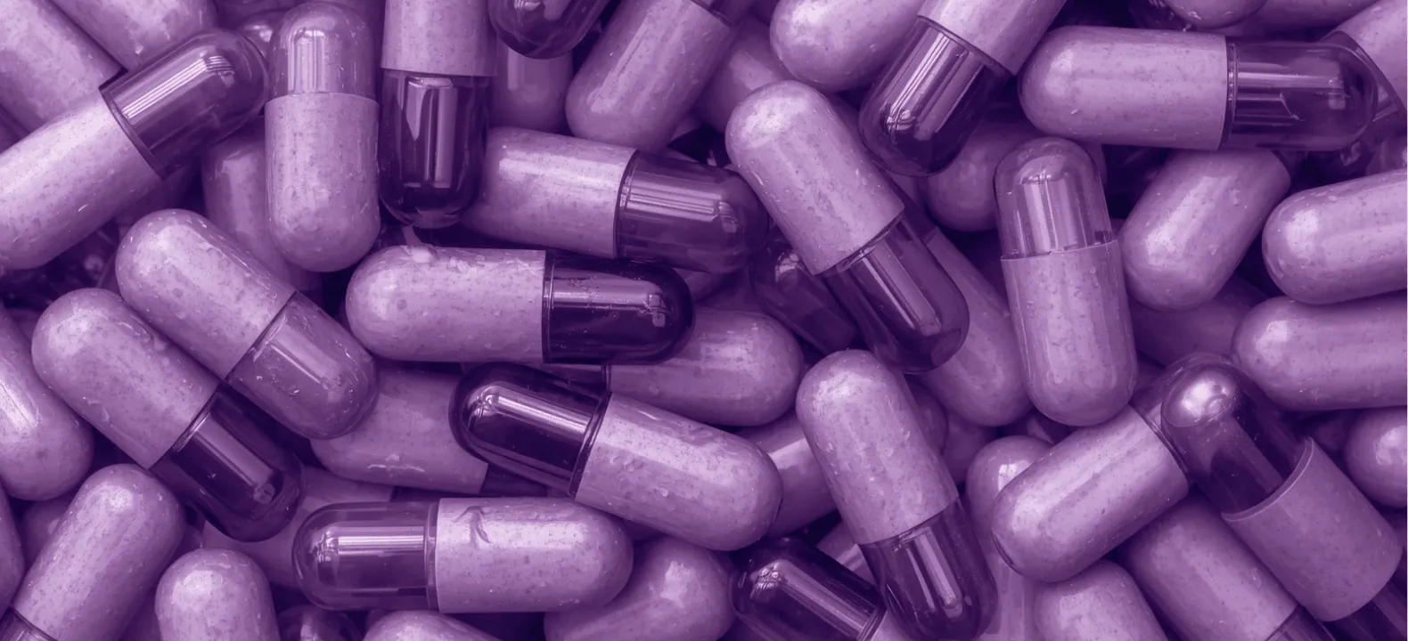 Gros plan de gélules en teinte violette, évoquant le traitement du TDAH
